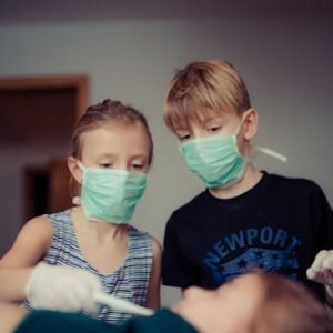 Kids playing as doctors, wearing masks and gloves in a healthcare role-play.