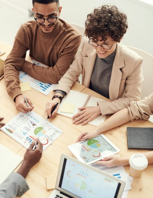 A diverse team of professionals collaborating over charts and graphs during a business meeting.